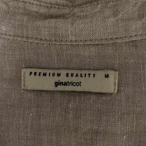 Beige linneskjorta från Gina Tricot - Säljer en stilren beige skjorta från Gina Tricot i linne. Skjortan har långa ärmar och knappar framtill, perfekt för en avslappnad look.