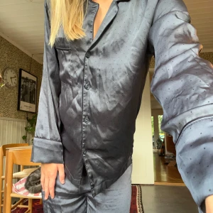 Blå pyjamas  - Jätteskön pyjamas i blåfärg och med prickiga detaljer🎲 smärre defekten förekommer på byxa i form av nopper. Annars fina och inte använda särskilt ofta. Känns som silke men är polyester 