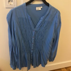 blus - Blus i nyskick ljusblåa 