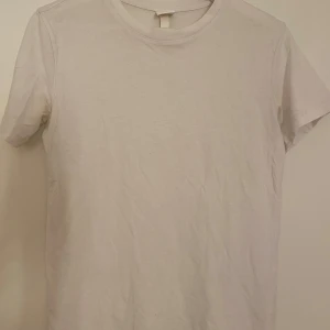 Vit basic t-shirt  - Enkel och stilren vit t-shirt från H&M Basics i storlek XS. Klassisk rund halsringning och korta ärmar. Gjord i mjuk bomull som är skön mot huden. 