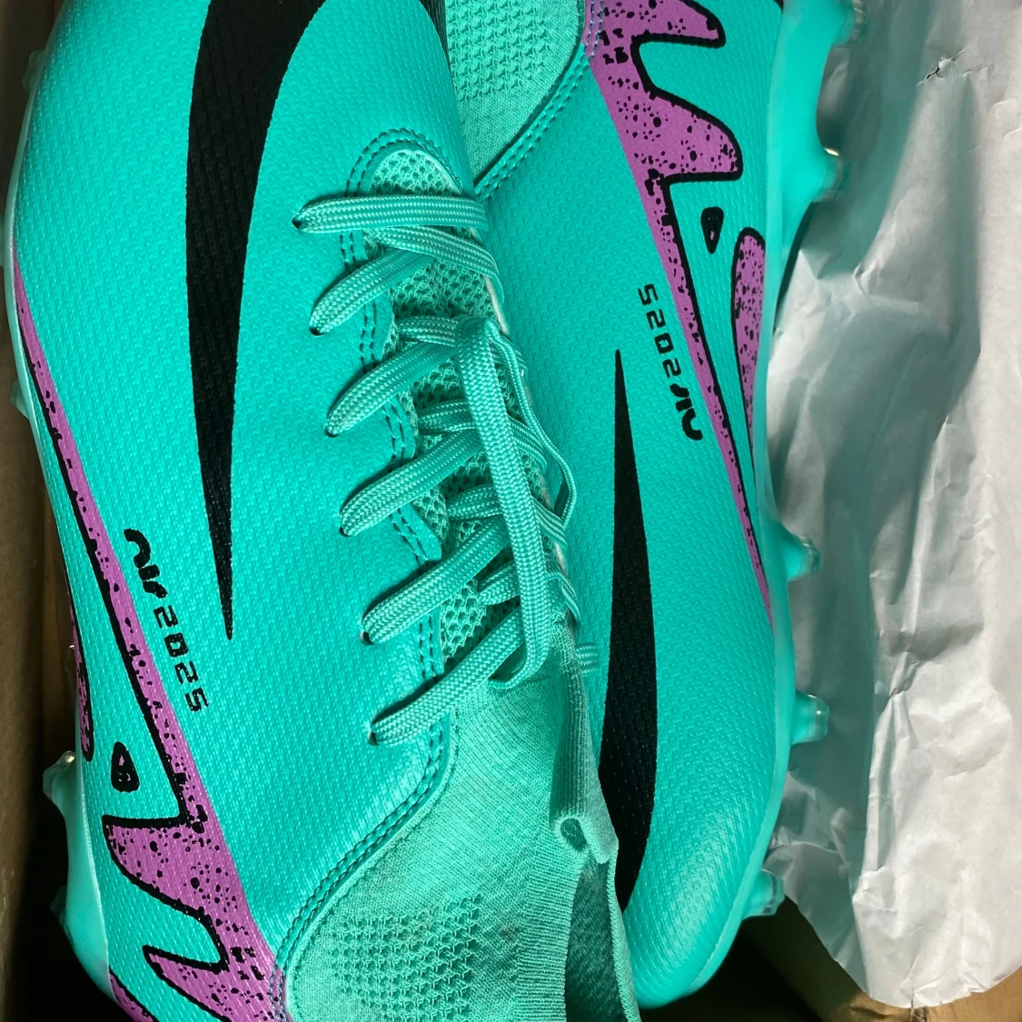 Turkosa fotbollsskor med lila detaljer