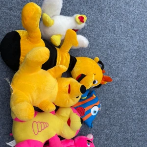 Sex stycken nallar - Bilderna visar flera färgglada gosedjur, bland annat björnar, en bi, en fisk och en kyckling. Ingen bok syns på bilderna, endast mjukisdjur i olika färger och former. Perfekt för dig som gillar mjukisdjur eller vill ge bort till någon yngre.