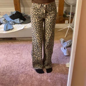 Leopardmönstrade wide jeans - Säljer ett par riktigt snygga jeans med leopardmönster och breda ben. Byxorna har klassisk femficksmodell, normal midja och är i ett robust bomullstyg. Perfekta för dig som vill sticka ut och köra en cool streetstyle. Skulle säga att de är mid-rise. 