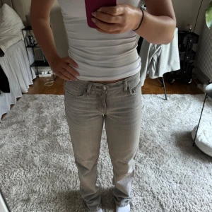 Ljusgråa jeans Ginatricot - Ett par lågmidjade raka jeans i storlek 32 från Ginatricot, i en superfin ljusgrå tvätt. Byxorna är nästintill oanvända då de är på tok för långa för mig som är 160 cm lång. Om du är intresserad men vill ha mer exakta mått är de bara att hojta till!🥰🥰