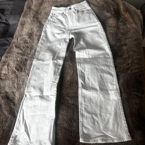 Vita wide jeans från H&M, strl 34 - Säljer ett par vita jeans från H&M i storlek 34. Byxorna har hög midja, raka ben med wide fit. Inga fläckar och i väldigt fint skick.