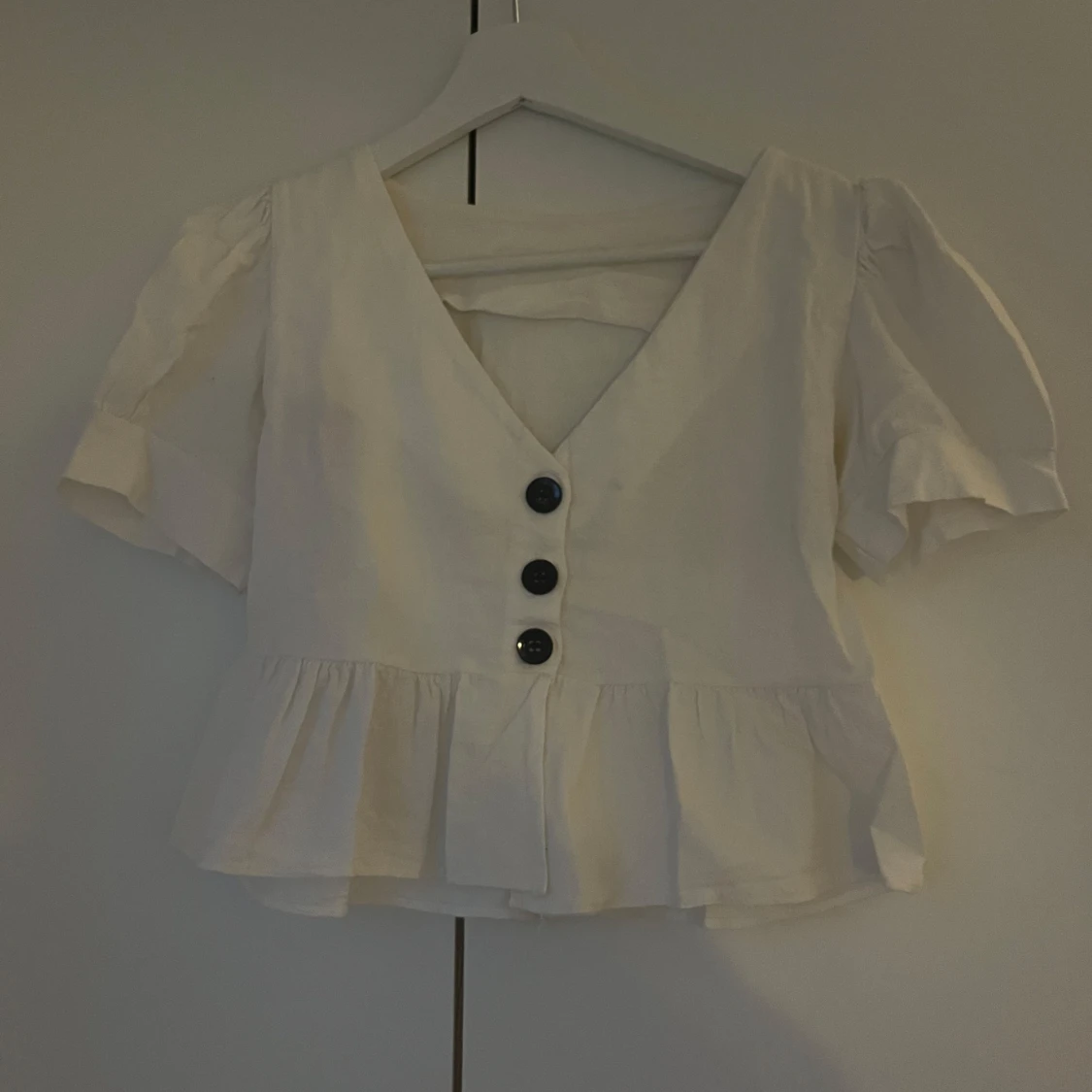 Vit blus med volang och knappar
