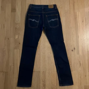 Nudie Thin Finn Blåa W29 L32 - Nudie Thin Finn Blåa W31 L32. Sitter dock som W29 L32 därav annan storlek i beskrivningen. Mycket sparsamt använda. Tveka inte på att höra av dig om du har några frågor eller funderingar!