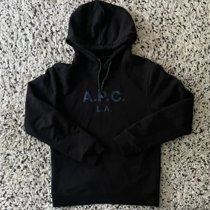 APC hoodie - Säljer denna APC hoodie, varsamt använd. Har en liten slitning på vänstra axeln (se bild 3), men inget märkvärdigt och är i övrigt i fint skick. Jag är för referens cirka 185.