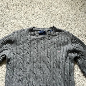 Stickad GANT tröja - storlek M - Helt vanlig grå stickad tröja från GANT. Inga defekter och nytvättad i bra skick. Normal i storleken.