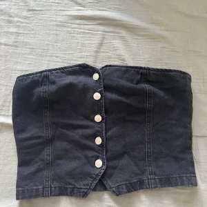 Svart jeans tubtopp från ASOS DESIGN - Svart tubtopp i jeansmaterial från ASOS DESIGN. Använd två gånger så i jättefint skick. 