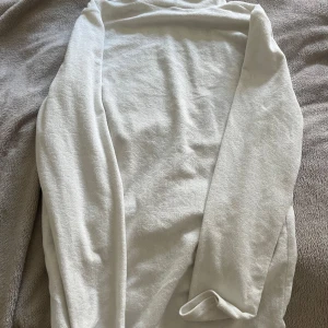 Vit polotröja från Black Squad L - Säljer en vit polotröja från Black Squad i storlek L. Tröjan har slim fit-passform, lång ärm och hög krage. Materialet är mjukt och stretchigt, perfekt för lager-på-lager. Enkel och clean look som funkar till många outfits.