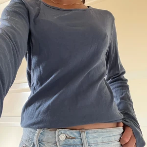 Blå långärmad tröja  - Enkel och stilren blå långärmad tröja med rund halsringning. Passar bra till jeans eller kjol och är ett måste i garderoben.