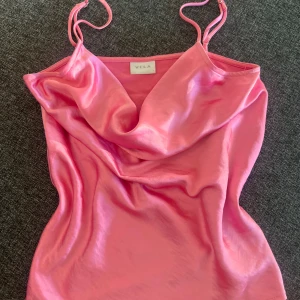 Rosa satinlinne från Vila - Supersnygg rosa linnetopp från Vila i glansigt satinmaterial. Toppen har tunna axelband och en draperad, lös urringning