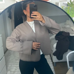 Beige omlott cardigan jacka - Säljer en beige cardigan jacka från GinaTricot med omlottknäppning och vida ärmar. Jackan har dekorativa sömmar längs kanterna. Jackan är i storlek xs men passa perfekt för xxs-m. 