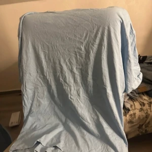 Ljusblå oversized t-shirt från FSBN - Enkel och stilren ljusblå t-shirt från FSBN i oversized modell. T-shirten är kortärmad och tillverkad i mjuk bomull, perfekt för en avslappnad look. Passar dig som gillar en loose fit och vill ha en basic tee i garderoben.