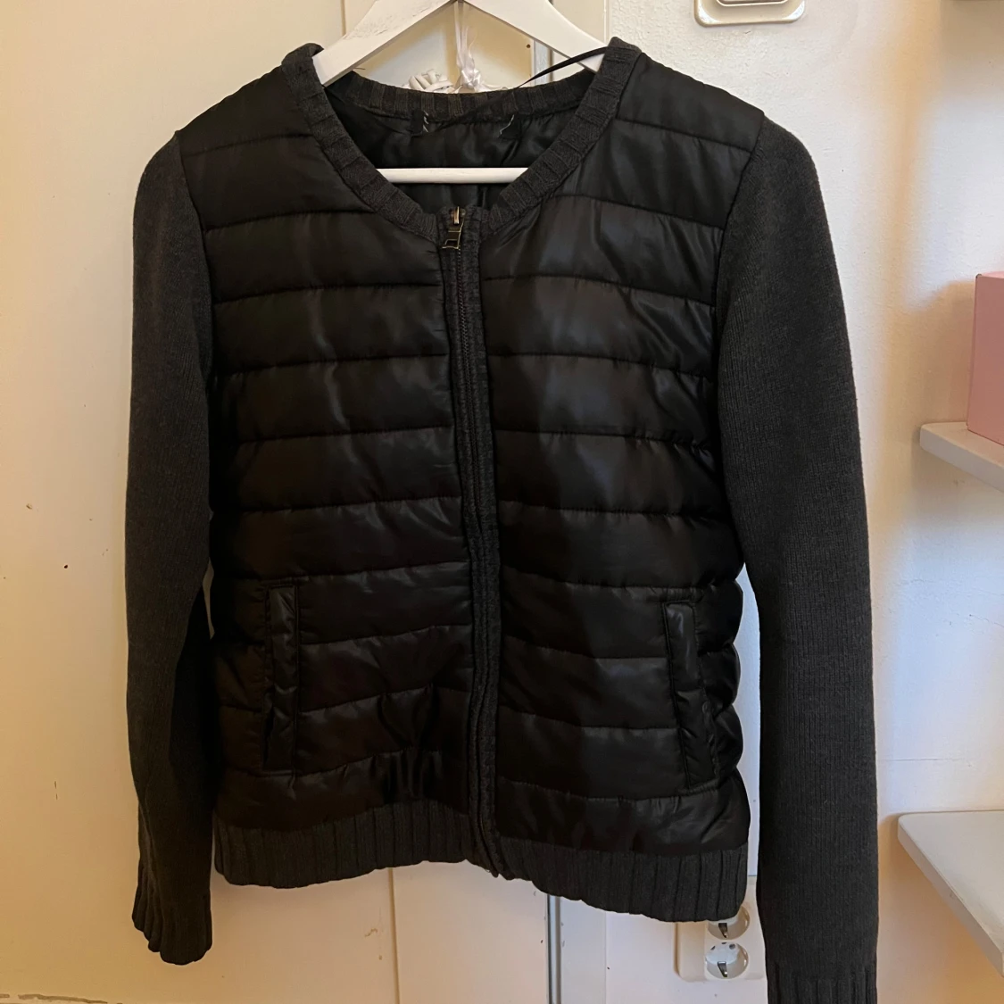 Svart quiltad jacka med stickade ärmar