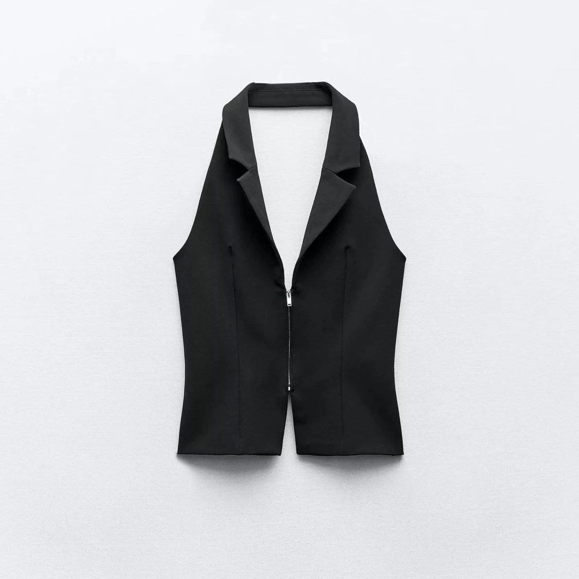 Svart väst med dragkedja och öppen rygg