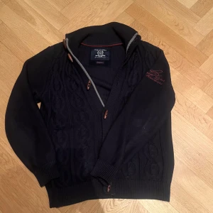 Cardigan Casa Moda - Säljer en riktigt snygg cardigan från Casa Moda med ett riktigt unikt stickat märke vid armen🍾Tröjan är i storlek S men sitter som en M💳Perfekt inför våren som både cardigan och jacka under våren🌱☀️Hör av vid funderingar🤝