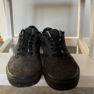 Vans Old Skool  - Säljer ett par svarta sneakers från Vans med snörning och den ikoniska vågformade sidodetaljen. Skorna är knappt använda 