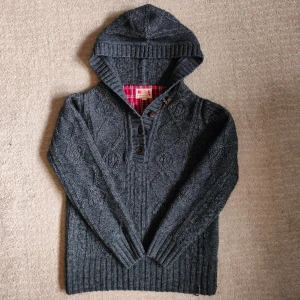 Unik Kabel stickad hoodie  - Säljer en kabel stickad hoodie från märket Mustang. fint skick samt väldigt snygg och unik. Hoodie har knappar och coola detaljer. Skriv vid minsta fundering!