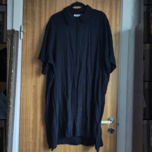 Svart skjortklänning från Weekday - Obs! Nackellacks-fläck på framsidan, nedre delen av skjortklänningen (se bilder). Säljer en svart, ostruken skjortklänning från Weekday i storlek L. Klänningen har en klassisk krage och knappar framtill. Perfekt för en avslappnad stil. 🖤