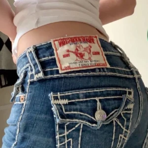 Flare jeans från True religon - Lågmidjade jeans från true religon med vita sömar. W27 Fint skick, slitage längst nere då jag gått på dom 