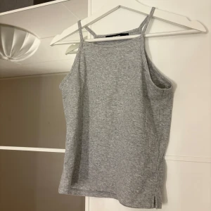 Grå ribbad linnetopp från Gina Tricot - Säljer en stilren grå ribbad linnetopp från Gina Tricot. Hör av er vid funderingar eller om ni vill ha bilder med hur plagget sitter på mig. Titta gärna in mina andra plagg!