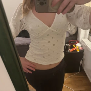 Vit blus från Kappahl - Säljer en söt vit blus från Kappahl med broderade detaljer och v-ringning. Blusen har trekvartsärmar och en omlott-design som ger en fin passform. Perfekt för vår och sommar!