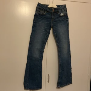 Blå jeans från Gina Tricot -  Från Gina Tricot i storlek 158. Med en knapp och dragkedja framtill. Jeansen har en lätt utsvängd bootcut/flared jeans. Varför säljer jag dem? För dem blev i fel storlek och hade inte kvitto, Dem har används en gång tidigare så helt nytt skick!