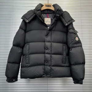 Svart dunjacka från Moncler - Snygg svart dunjacka från Moncler med knappar och dragkedja. Jackan har en quiltad design och långärmade ärmar. Perfekt för kyliga dagar med stil.
