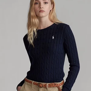 Mörkblå stickad tröja från Ralph Lauren - Snygg mörkblå stickad tröja från Ralph Lauren med kabelstickat mönster. Tröjan har långa ärmar och en liten broderad logotyp på bröstet. Perfekt för en stilren och klassisk look. Storleken är M! 