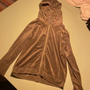 Beige hoodie med dragkedja - Säljer en gröngrå hoodie i mjukt material med dragkedja och huva.