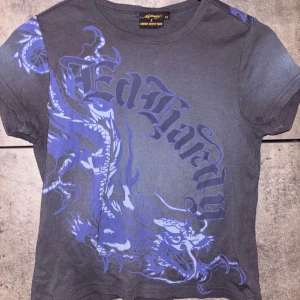 Ed Hardy T-Shirt - Kjøpt på Urban Outfitters i Stockholm ✨ Den er i størrelse M men passer nok like bra en S 🩵 Brukt 1 gang, men blir litt for tight over brystet om man har E-cup eller større 🥲 