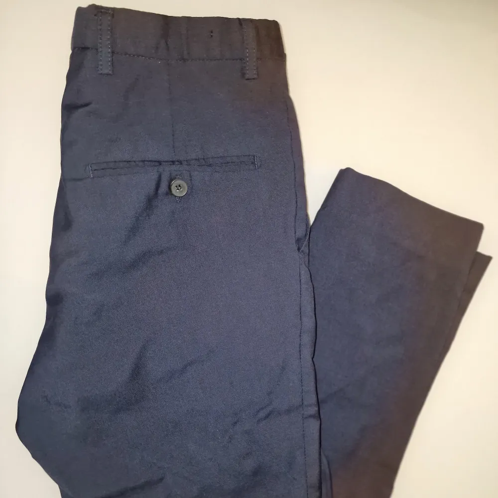 Snygga mörkblå kostymbyxor med en stilren look. De har en klassisk passform och är tillverkade i ett bekvämt material.. Farkut & Housut.