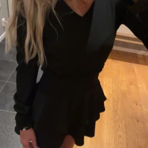 Svart volangklänning Gina Tricot❤️ - Supersnygg svart klänning från Gina Tricot med volangdetaljer i kjolen och v-ringad hals. Säljer då den har blivit för liten och för kort för mig som är ungefär 1,62cm❤️Använd två gånger vilket gör att den är i ett bra skick! 