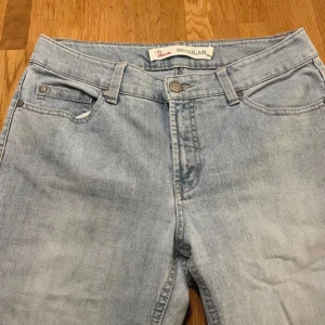 Ljusblå raka jeans från Denim, stl 40 - Snygga ljusblå jeans från Denim i rak modell med klassisk femficksdesign. Jeansen har normalhög midja, bälteshällor och knapp med hjärtdetalj. Perfekta för dig som gillar en enkel och clean look. Materialet är mjukt denimtyg. Passar även 38