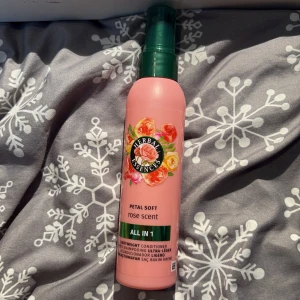 Herbal Essences Petal Soft Rose Scent - Herbal Essences Petal Soft Rose Scent all-in-one spray i rosa plastflaska med grönt lock. Doft av rosor och blommigt tryck på framsidan. Perfekt för dig som gillar fräscha och blommiga dofter i din hårvårdsrutin.