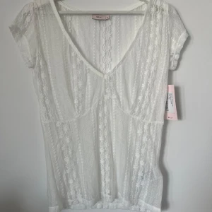 Topp - Festlig genomskinlig topp med spets. Helt ny och oanvänd med prislappen kvar.