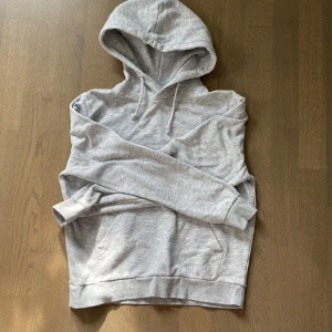 Ljusgrå hoodie från SOC XS - Säljer en ljusgrå hoodie från SOC i storlek XS. Tröjan har huva med snörning, magficka och långa ärmar. Perfekt för chill dagar eller när du vill vara extra bekväm. Mjuk insida och klassisk passform.