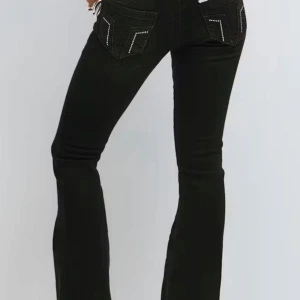 Svarta bootcut jeans med detaljer - Snygga svarta jeans med bootcut passform, dom har silver detaljer på baksidan. Storlek 158, nassar dig som är runt 162-165 och som vanligtvis bär xxs-s då dom är väldigt stretchiga 