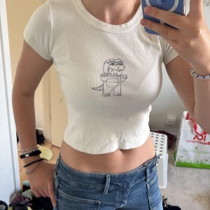 Creme vit topp från brandy - Supersöt croppad topp från Brandy Melville med gulligt tryck på bröstet. Skriv om ni har frågor💕