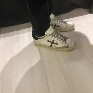 Vita sneakers från Premiata - Snygga vita sneakers från Premiata med grå snörning och svart häl. Nypris 2700 kr. Okej, skick, slitna i hälen och lite på sulan. Pris kan diskuteras, hör av dig vid minsta fråga!
