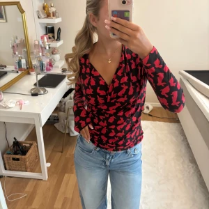 Svart omlottopp med röda kaniner - Super skön o cool topp från Camilla Thulin, ursprungligen kostar den 1500, bra skick