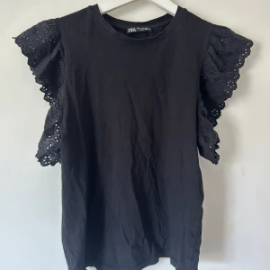 Svart topp med volangärmar från Zara - Svart topp från Zara med breda, broderade volangärmar i bomull. 💞💞