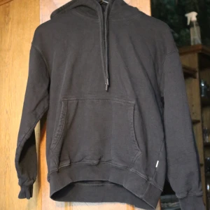 Svart hoodie från Vailent med huva - Svart hoodie från Vailent i storlek S. Klassisk modell med huva, snörning och stor magficka framtill. Mjuk och skön, perfekt för chill dagar. Långärmad med ribbade muddar och avslappnad passform. Använd typ 4 gånger