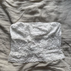 Vit spets bandeau tubtopp - Supersöt vit bandeau tubtopp med blommig spets och mjuk insida. 