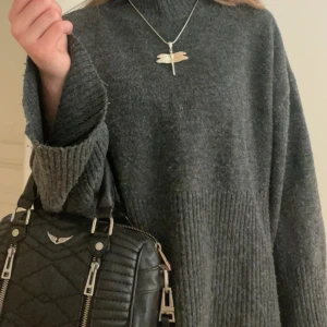 Mörkgrå stickad polotröja - Säljer en mörkgrå stickad polotröja med ribbade detaljer vid halsen, ärmsluten och nederkanten. Perfekt för kyliga dagar🩷Enkel och stilren design som funkar till många olika outfits🩷