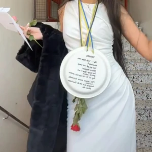 Vit långklänning med drapering - Säljer en elegant vit långklänning med snygg drapering längs sidorna. Klänningen är ärmlös och har en figurnära passform som framhäver siluetten. Perfekt för student eller sommarens speciella tillfällen. Materialet känns mjukt och följsamt mot kroppen.