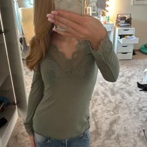 Olivgrön spetsdetaljerad topp Intimissimi - Supersnygg olivgrön långärmad topp från Intimissimi med v-ringning och spetsdetaljer vid halsringning och ärmslut. Tight passform och tillverkad i en mjuk blandning med kashmir. Älskar verkligen dessa tröjor men vill köpa denna i en annan färg 🤗💗Använd max 3 gånger
