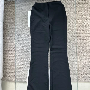 Svarta bootcut byxor med hög midja - Snygga svarta byxor med bootcut-ben och hög midja. De har en klassisk look och är tillverkade i ett stretchigt material som sitter bekvämt.